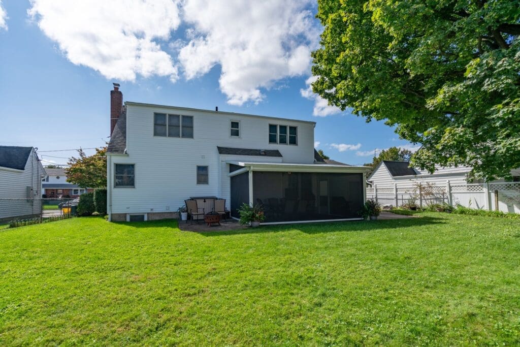 Backyard view of a white two-story house.